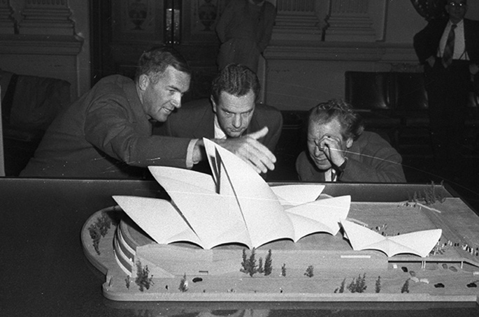 Utzon and two other men scrutinising a model of the Opera House.