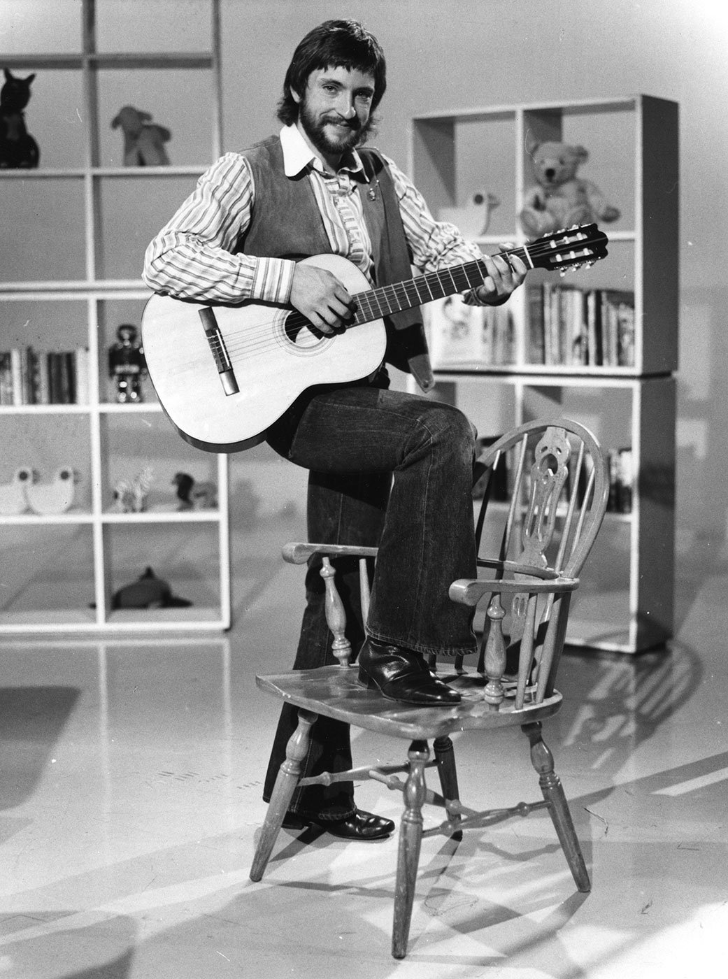 John Waters playing a guitar.