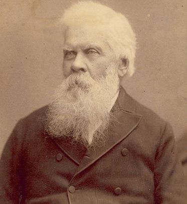 studio photographic portrait of older man, with white hair and long white beard