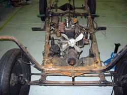 Rusting car frame and engine.