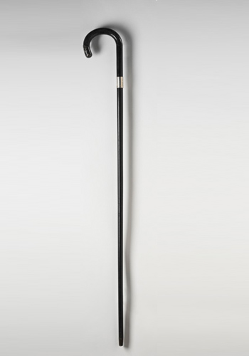 Ebony walking stick with a curved top, a small silver metallic band and a metal cap at both ends.