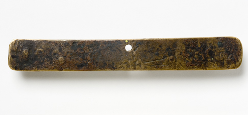 Back view of the Leichhardt nameplate. The greyish-brown surface of the nameplate appears uneven and there are two score marks at the bottom close to the centre and a fastening hole at the top in the centre.