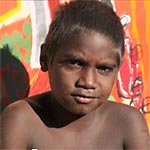 Aboriginal boy in front of a painting