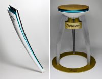 Olympic torch and cauldron On the left is an image of an Olympic relay torch coloured silver, aqua blue and white, with a silver logo on each side. On the right is an image of an Olympic community metal cauldron with a white, blue and silver coloured cone shaped dish supported by three curved legs. The legs are attached to a yellow circular base. 'Sydney 2000' is printed three times in black on a yellow band under the base of the dish. 'SYDNEY 2000 / OLYMPIC TORCH / RELAY / PRESENTING PARTNER / AMP' with Sydney 2000 logo and Olympic rings is repeated three times on base and printed on top.