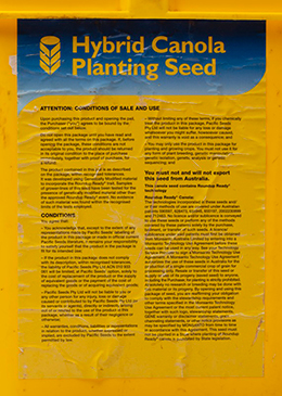 Conditions of sale and use label on Pacific Seeds 'Hybrid Canola Planting Seed' bucket.