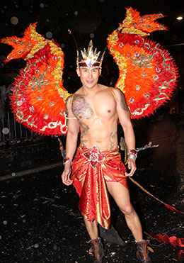 Tattooed man wearing orange dragon wings