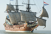 Wreck of the Batavia Timber sailing vessel at sea with lower sails catching the wind. The Dutch flag sails from the bowsprit.