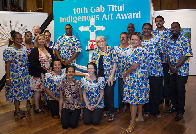 Group photo of men and women in brightly-coloured uniforms
