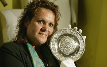 Evonne Goolagong Cawley, wearing white cotton gloves, holds a small silver plate.
