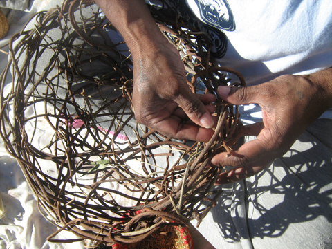 Person weaving a wooden basket