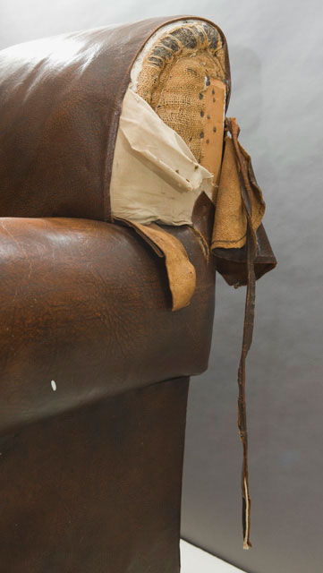 Detail showing damage to the right shoulder of the chair.