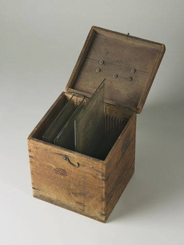 Wooden box, specially made to house glass plates, shown with its lid open.