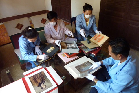 Staff from Collections and Exhibitions section examining for pests and cleaning photographic archive material in preparation to rehouse the collection.