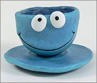 A blue clay model of a cup and saucer.