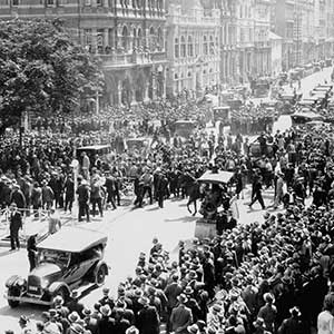 Photo taken from a second-storey window showing hundreds of men proceeding down a main street.
