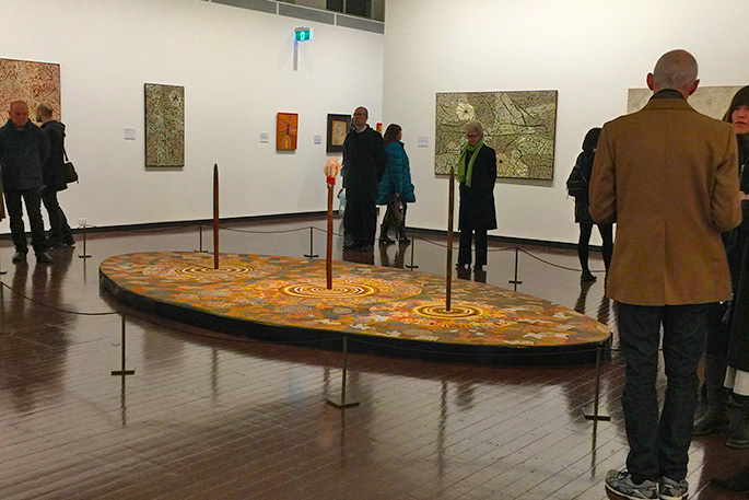People standing in a gallery looking at an artwork exhibiton.
