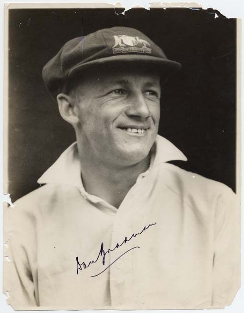 Donald Bradman smiling in a portrait photo, photo is also signed by Bradman