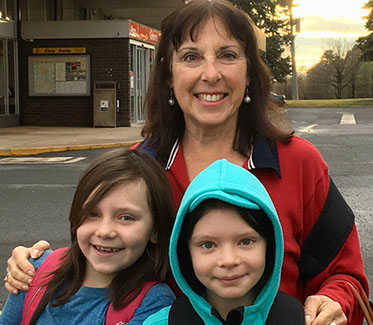 A woman standing behind two girls