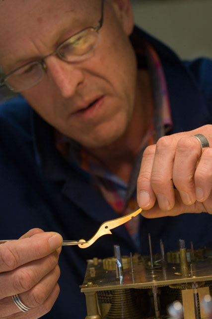 The strike repeat lever is inspected before installation.
