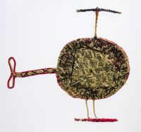 Flat chopper A sculpture depicting a helicopter. The sculpture is made of woven grass and plant material dyed in different colours.