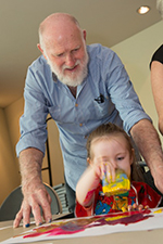Get messy-Grandpa A cropped colour photograph of a man and a young boy particpating in a craft activity.