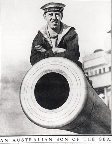 A sailor of the HMAS Australia poses on top of the battle-cruisers mighty guns.