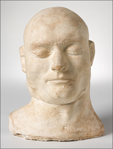 studio photo of a white plaster head. The eyes are closed and the expression appears calm.