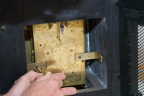 Brass brackets secure the movement to the internal walls of the case.