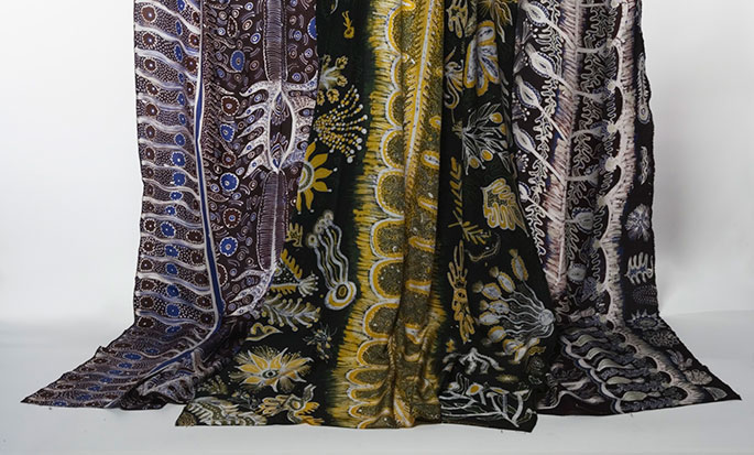 Silk batik fabric with Ernabella motifs in yellow, black, blue and white.