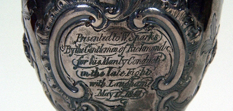 A close up of engraving on the Sparkes cup, a nineteenth century solid silver goblet.