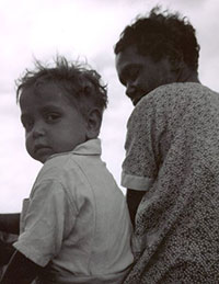 Black and white photo of a young boy with his mother.