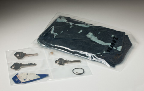A dark blue leather wallet inside a plastic pouch, alongside another plastic pouch with six small compartments. These contain three silver keys, a remant of a blue plastic tag, a small metal ring and a metal earring fixture.