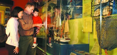 Junie, Tom and Conor Ryan explore the Paipa exhibition in the First Australians gallery