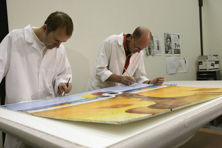 Museum conservators David Parker and Peter Bucke remove debris from the surface of the paintings using soft brushes.