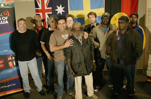 Indigenous community representatives with Amanda Vanstone and Jorgen Frotzier, standing in front of Australian, Swedish and Aboriginal and Torres strait Islander flags