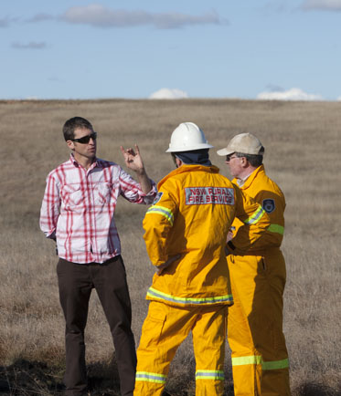 Curator and firemen in field