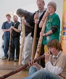 Visitors at the Museum learning to play the didgeridu.