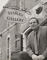 Photograph of Bill Derham in front of the Stables Gallery.