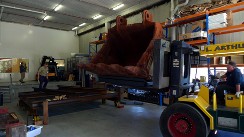 The rock bucket being lowered onto a heavy duty platform inside the loading bay. The rock bucket itself is sitting a specially design cradle.