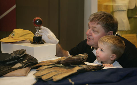 Swan Richards shows a young Museum visitor Wally Grout's record-breaking ball and other cricket gear including a cap and gloves.