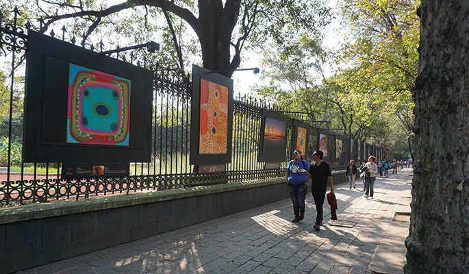 Large graphic panels installed on perimeter fence with pedestrians walking by