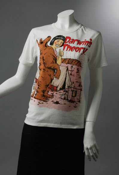 Souvenir T-shirt which reads 'Darwin's Theory' and shows a woman resembling Lindy Chamberlain giving the thumbs up while holding a dingo skin, outside a tent.