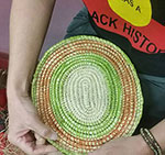 Ronnie Jordan weaving 200w Cropped image of two hands holding a small circular woven mat