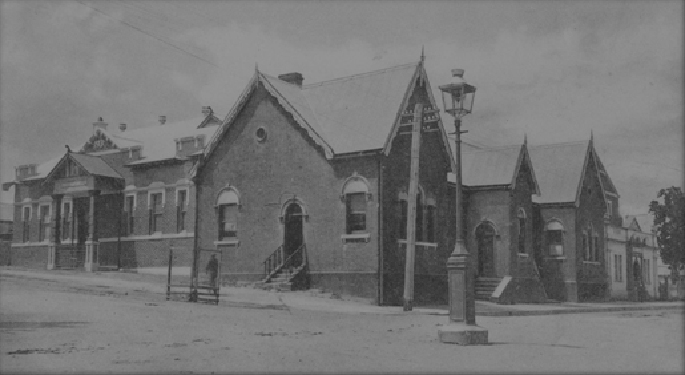 photograph of a building on the corner of an all-but deserted street. It looks like a large, rambling church hall