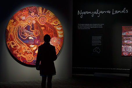 A silhouette of someone viewing an artwork in the shape of a circle