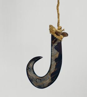 Large fishhook made of dark purple pinna marina shell with strings made of various plant fibres attached.