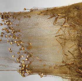 Large fishing net of whitish parau with numerous weights of white coral tied with strands of plaited coconut fibre along the lower long sides, and floats of small parau sticks along the upper long sides.