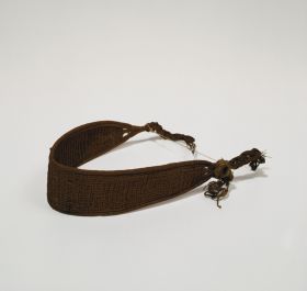 Headband made of plaited plant fibre that tapers towards the two ends with several plaited strings to fasten it.