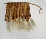 Tufts of dog hair bundled together into twenty-two tassels and tightly wrapped both length-wise and crosswise with fine coconut fibre threads and threaded onto a stick.