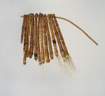Tufts of dog hair bundled together into thirteen tassels and tightly wrapped both length-wise and crosswise with fine coconut fibre threads and threaded onto a stick.